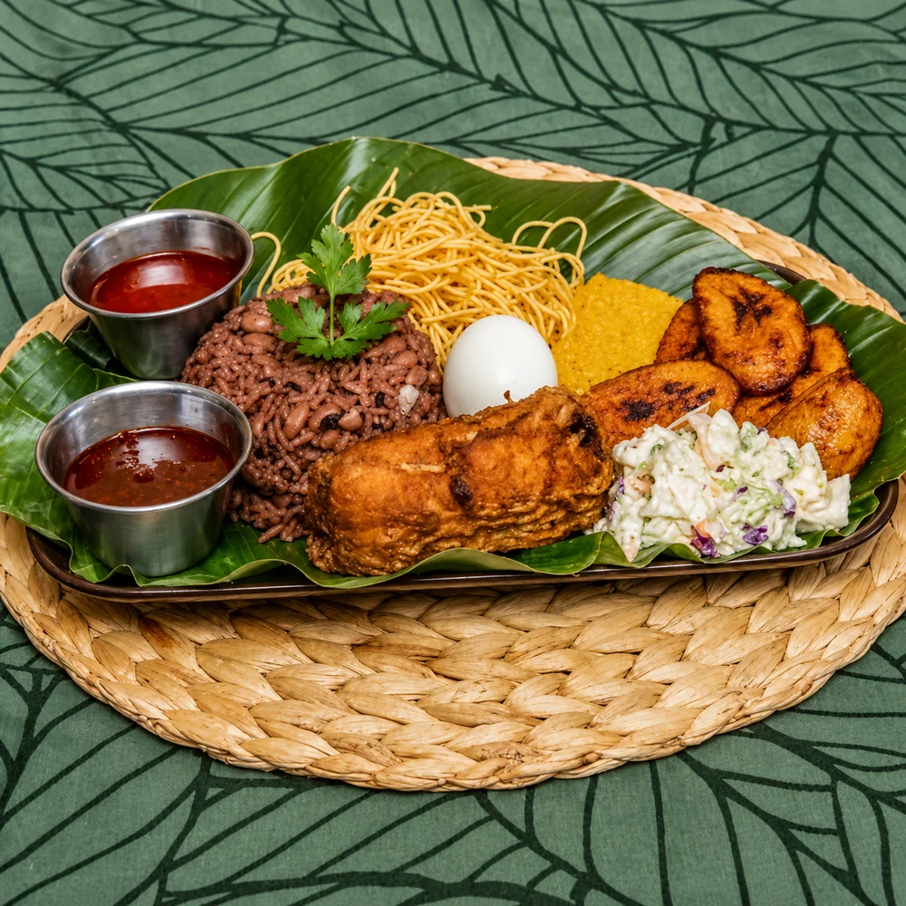 Waakye tray with rice and beans, spaghetti, boiled egg, fried fish, plantain, coleslaw and two pots of shito